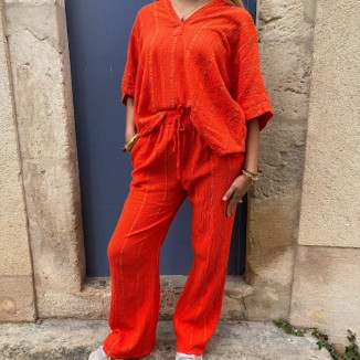 Blouse et pantalon orange brodé portés par une femme et vue de face