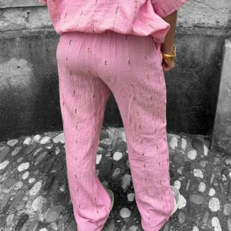 Pantalon rose brodé vue de derrière et porté par une femme