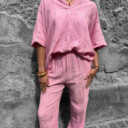 Pantalon rose brodé vue de face et porté par une femme avec le chemisier assorti