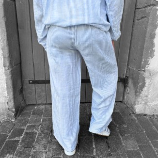 Pantalon rayé pascale de couleur bleu et blanc vue de derrière et porté par une femme