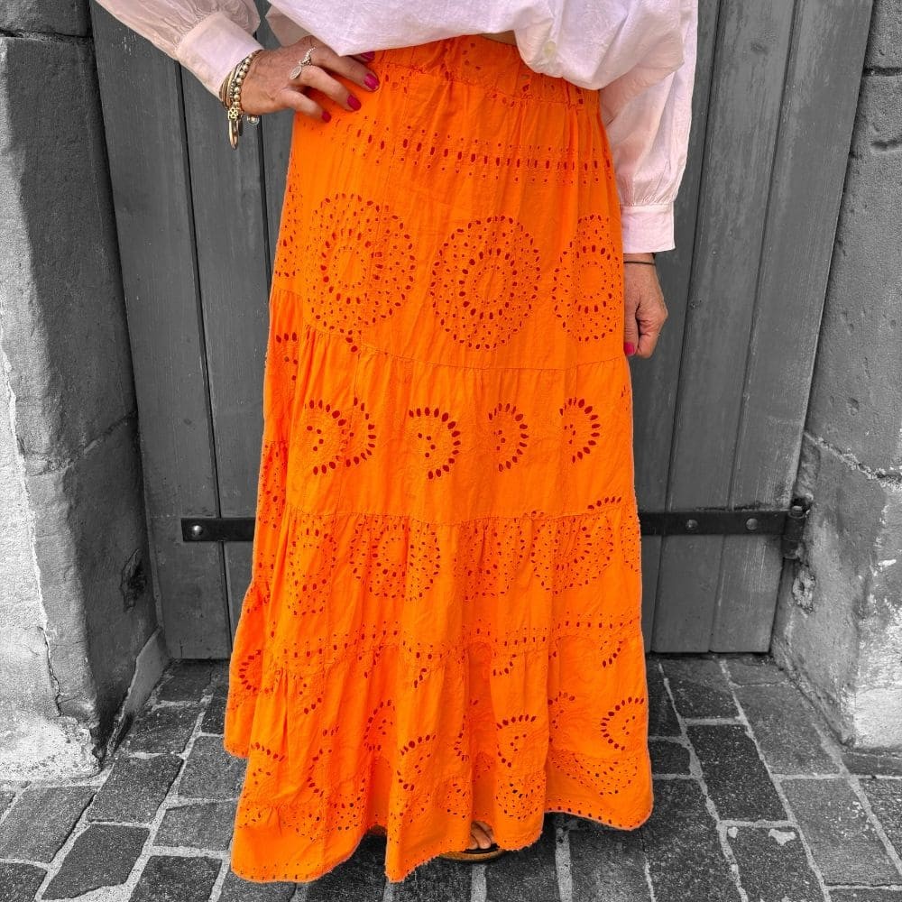 Jupe longue brodée de couleur orange vue de face et portée par une femme