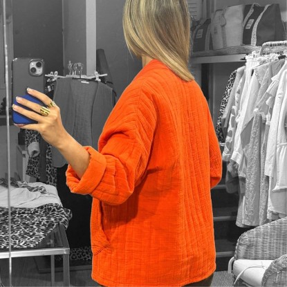 Veste kimono Ophélie orange vue de derrière dans un miroir et portée par une femme