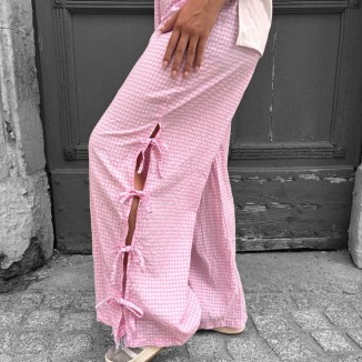 Pantalon vichy à trois noeuds de couleur rose vue sur le côté et porté par une femme