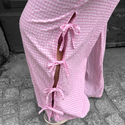 Pantalon vichy à trois noeuds de couleur rose vue de près et porté par une femme