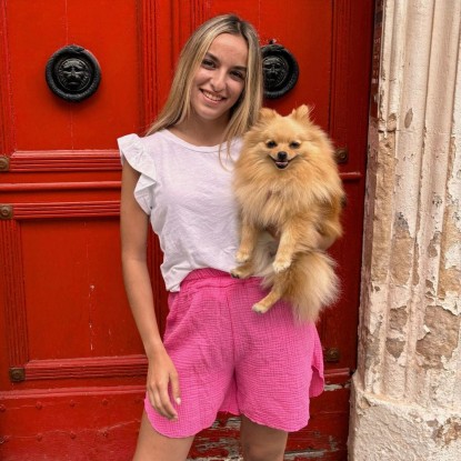 Top à volants Marie île de Ré de couleur blanc vue de face et porté par une femme avec un chien et un short rose