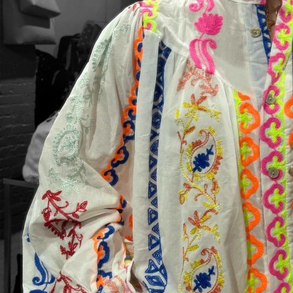 blouse Garance vue de près avec ses détails colorés dans un miroir et portée par une fille