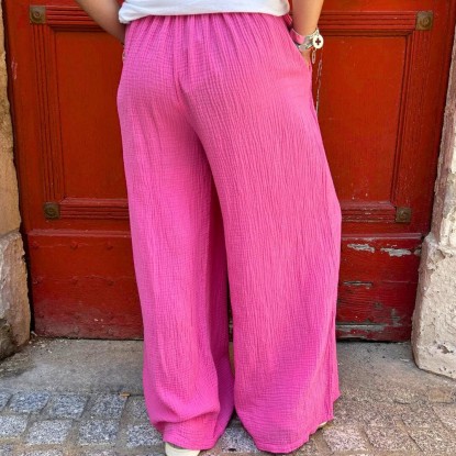 Pantalon en gaze de coton de couleur rose vue de derrière et porté par une femme